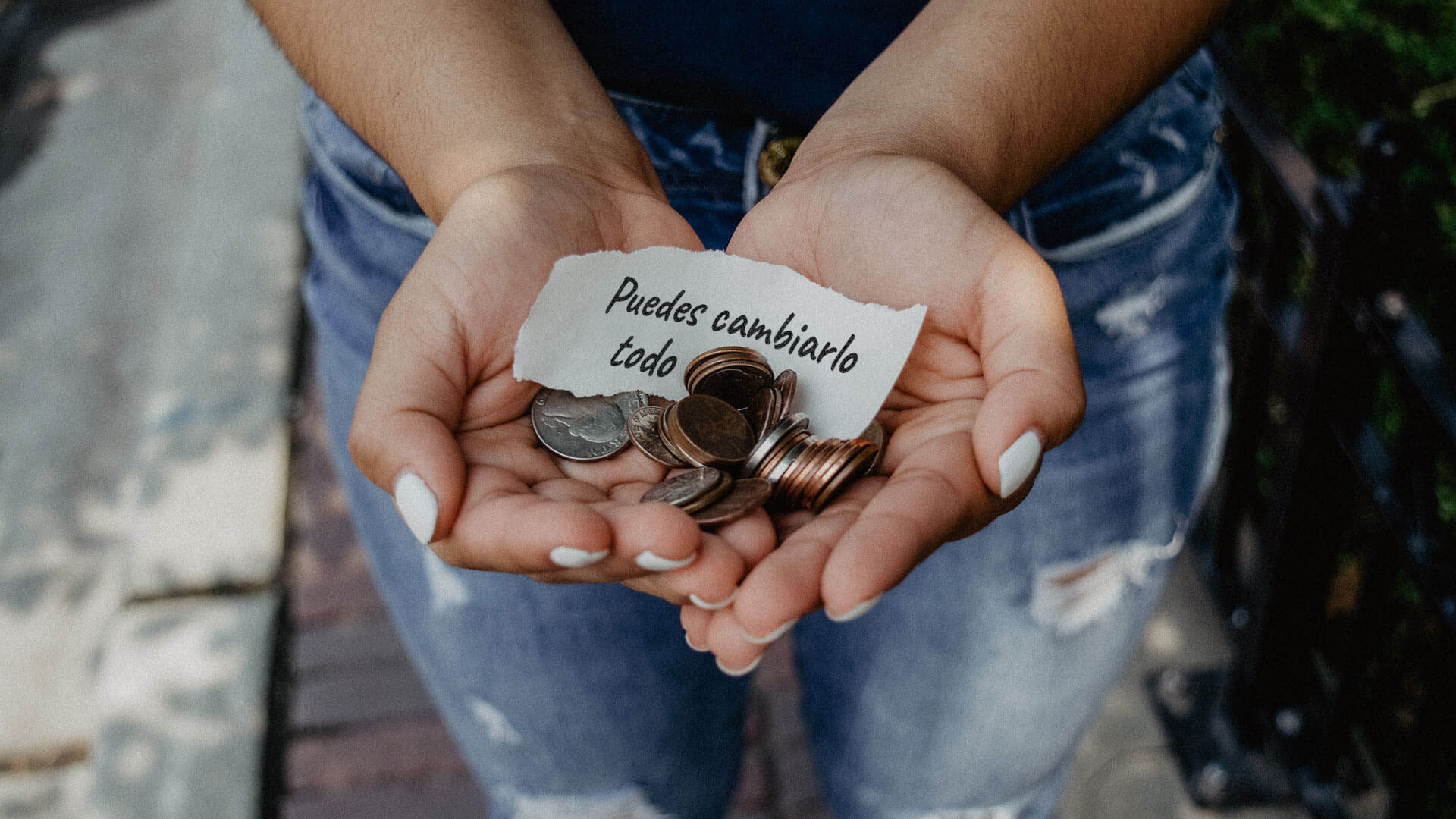 manos con monedas y un mensaje en papel: puedes cambiarlo todo